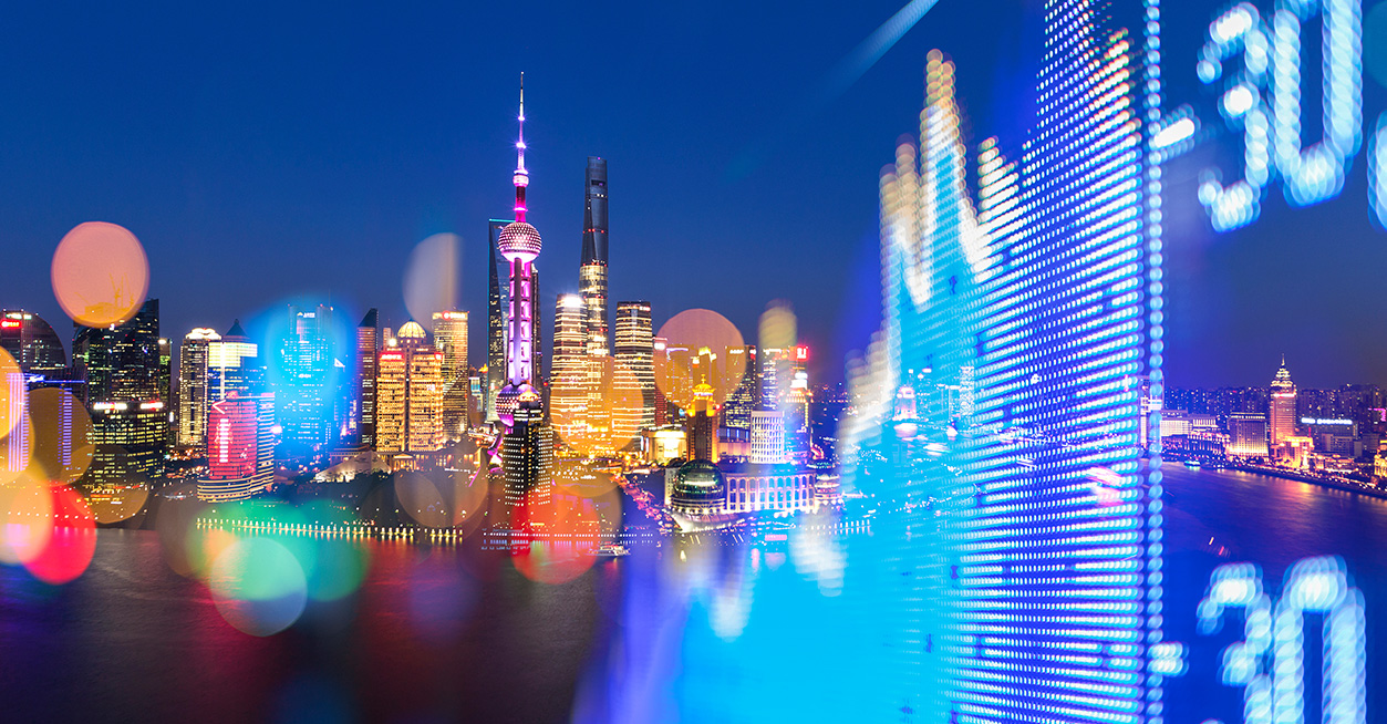 Skyline notturno di una città moderna con grattacieli illuminati e a destra un grafico finanziario stilizzato